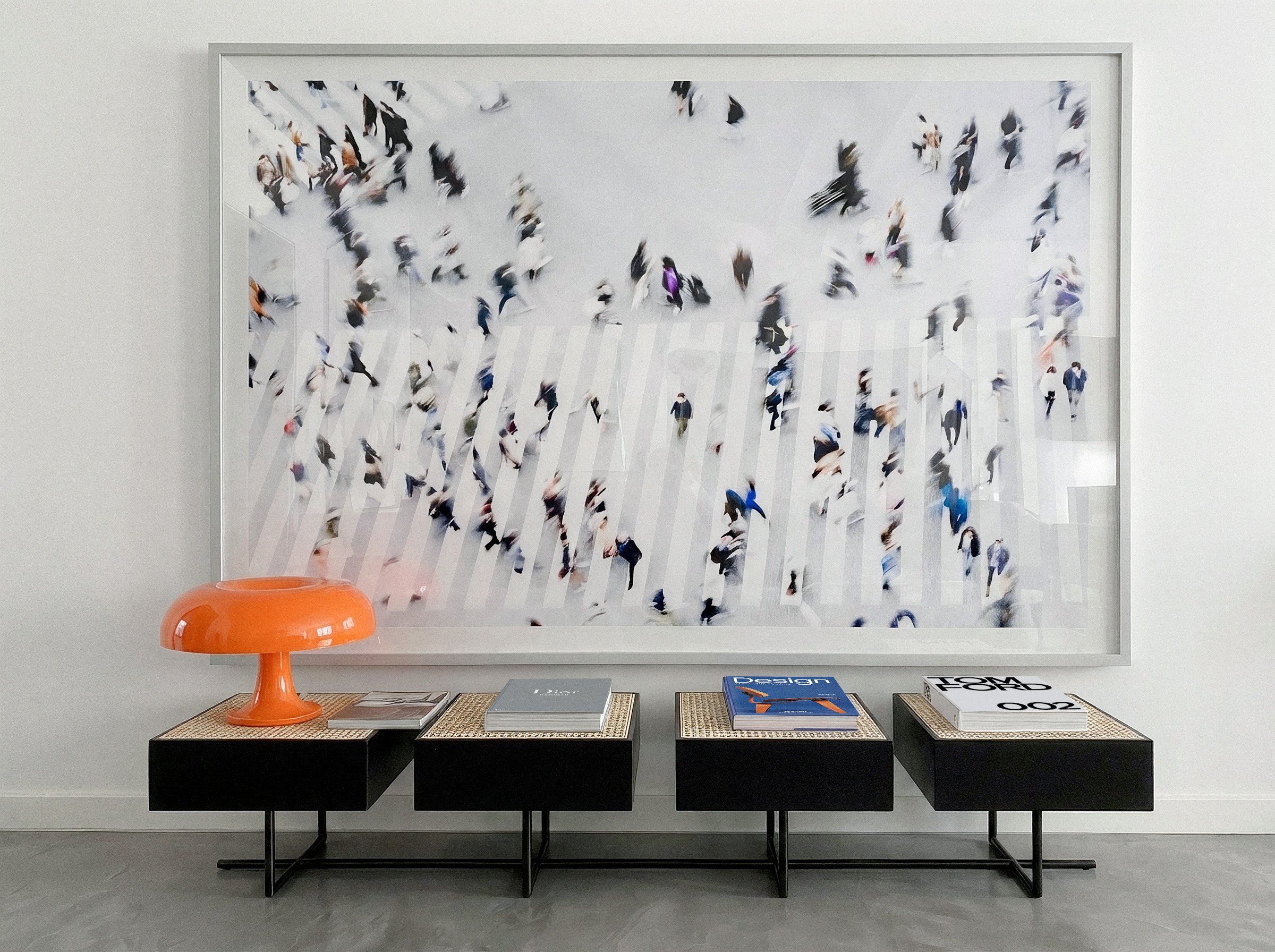 Obra da série IN MOTION emoldurada na parede, sobre bancos com livros de arte
